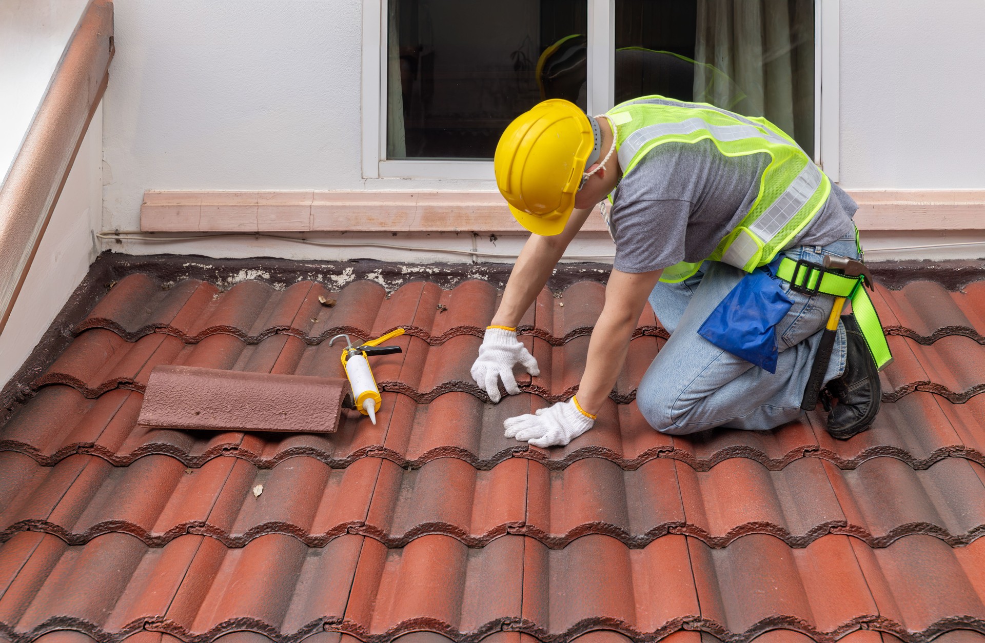 Construction worker is inspecting roof tile cracked.