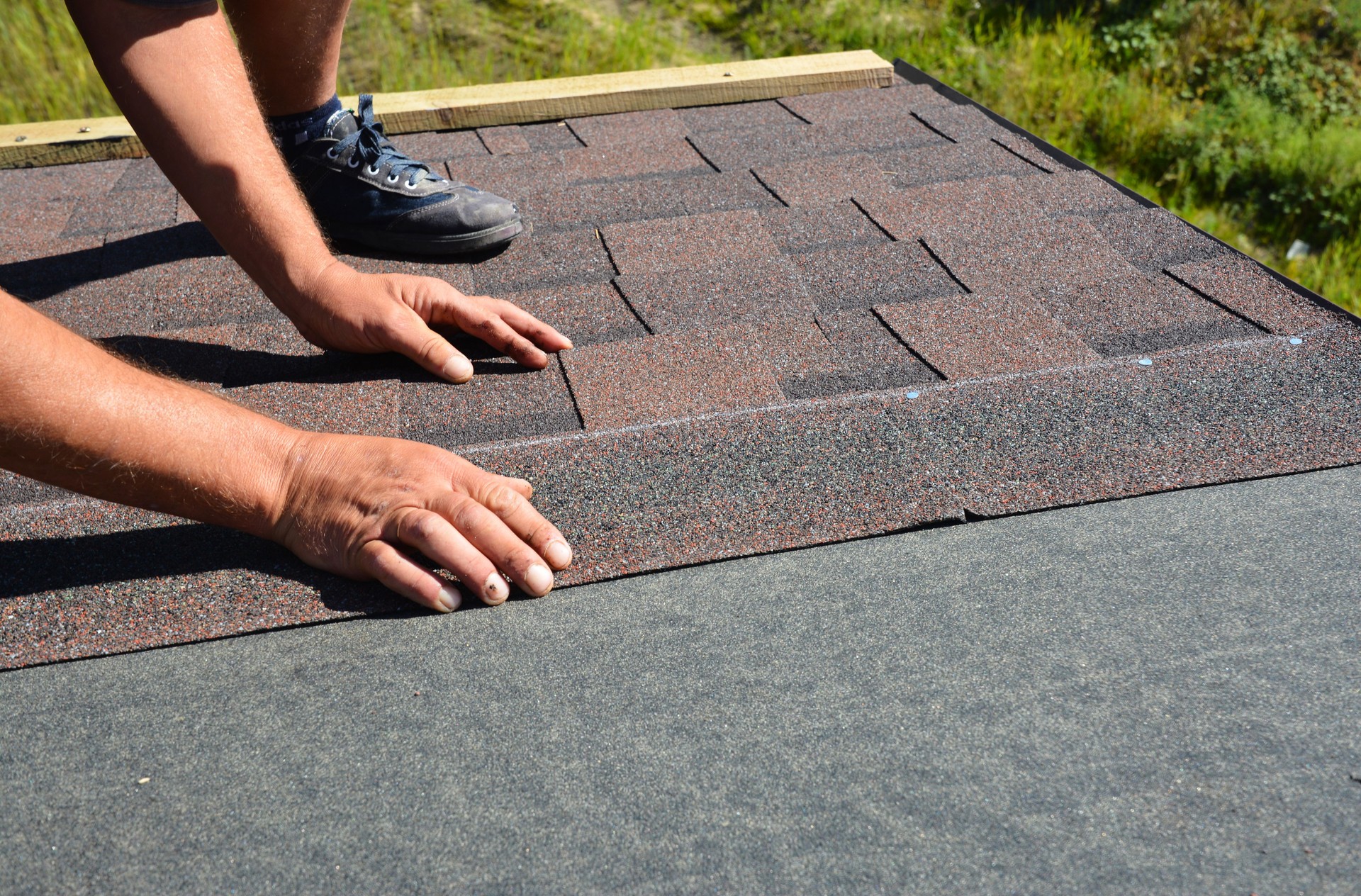 Roofing contractor lay asphalt shingles tiles on house rooftop. Asphalt shingles roofing construction, repair, installation, replace, renovation.